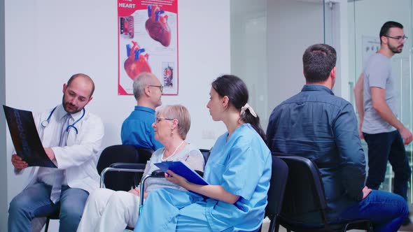 Medical Staff Discussing Diagnosis with Disabled Senior Woman alt