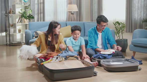 Family Packing Clothes In A Suitcase For A New Journey. Luggage For Travel Holidays And Vacation alt