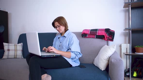 A woman blogger writes an article on a laptop for a social network. 