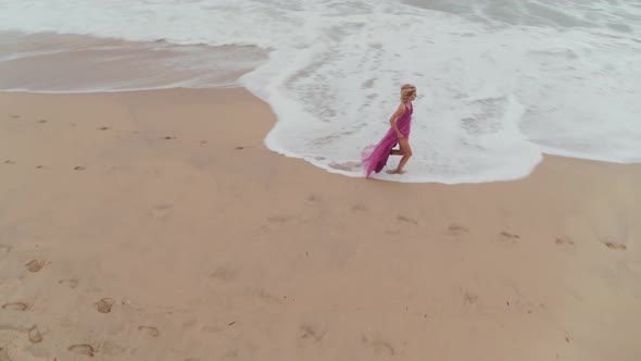 Woman In A Dress Wandering On The Beach alt