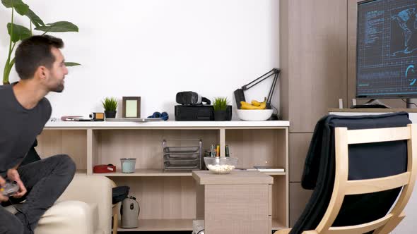 Stressed Man Playing a Video Game on the Console in the Living Room alt