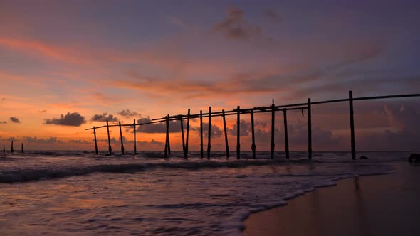 The old wooden bridge and sea wave on the beach at Khao Pilai, Phangnga, Thailand. alt