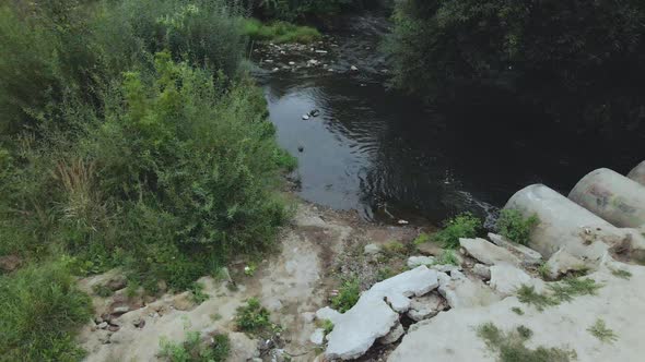Flying over concrete sewers. Streams of water flow through concrete pipes. alt