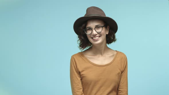 Flirty Young Woman in Glasses and Trendy Hat Laughing and Looking Coquettish Smiling at Camera