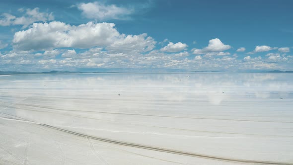 Flying over of Salar De Uyuni reflection water salt lake, desert in Bolivia 4K