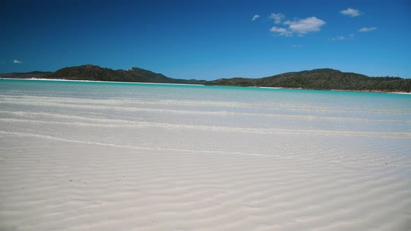 Whitehaven Beach with Small Waves on the Shoreline on a Sunny Day alt