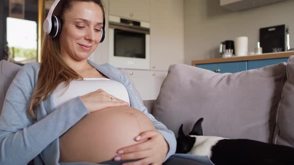 Pregnant woman listening woman by headphones. Shot with RED helium camera in 8K alt