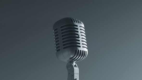 A desaturated vintage microphone on the stage. Closeup. Grey background. Old mic alt