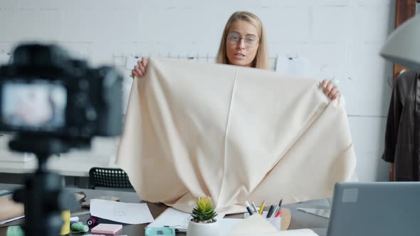 Confident Woman Tailor Recording Video About Dressmaking Using Modern Camera in Workshop alt