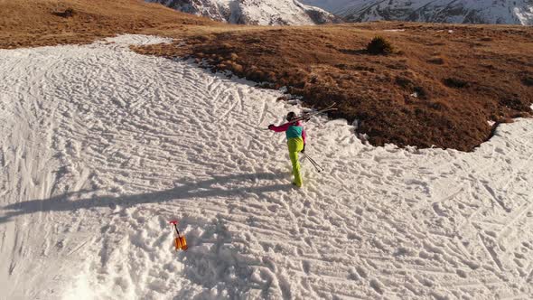 Aerial View Girl Athlete Skier Climbs on Foot Along the Slope with a Snowboard on His Shoulders Next alt