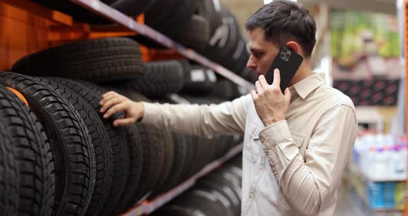 Customer Choosing Tires and Consulting with Somebody By Phone