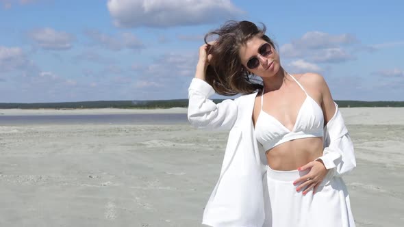 Charming Woman Standing on Beach on Windy Day