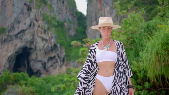 Woman Spending Time on Her Vocation at Tropical Beach She Walks Against the Mountain alt