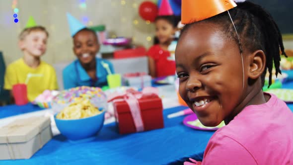 Portrait of smiling girl sitting with friends at table during birthday party 4k alt