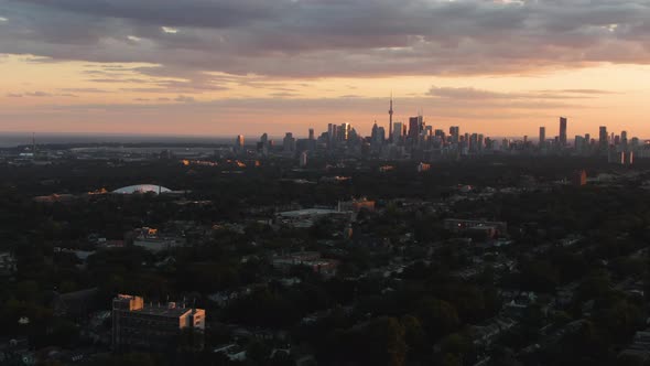 A sunset over Toronto. City skyline as seen from the distance. Cloudy sky alt
