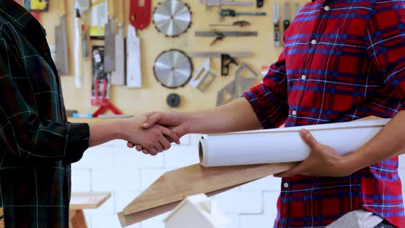architect and carpenter woman take a handshake together to deal wooden project