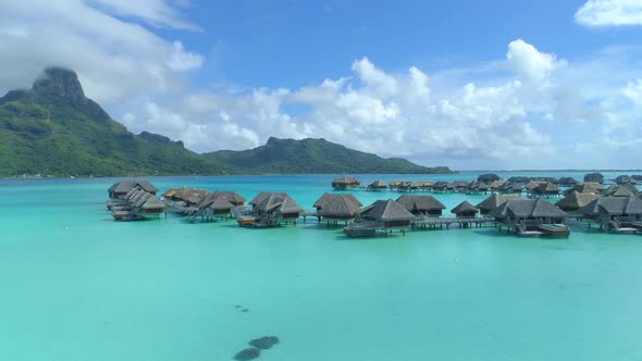 Aerial drone view of a luxury resort and overwater bungalows in Bora Bora tropical island. alt