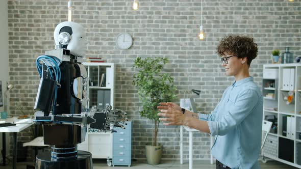 Smiling Woman Controlling Robot Testing Response, Machine Copying Movements alt