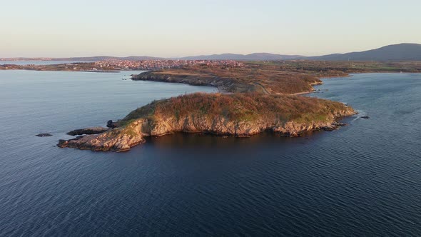 Shore with Grass and Hotels in the Distance Surrounded By the Black Sea Under a Clear Sky alt