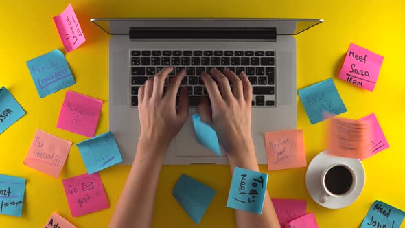 Office Worker Using Laaptop Tired and Loaded with Work Post It Papers