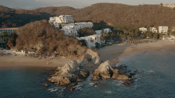 Winter sunset on pacific coastline. Hotels and villas near rocky beaches