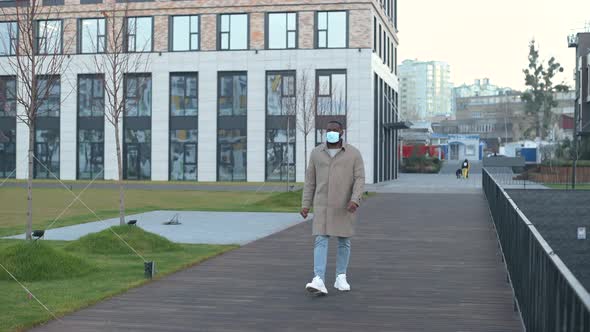 AfricanAmerican Guy Walking Down the Street Wearing Medical Mask