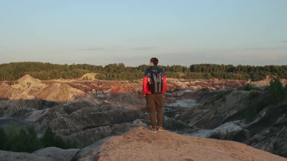 A tourist standing on the edge of a cliff