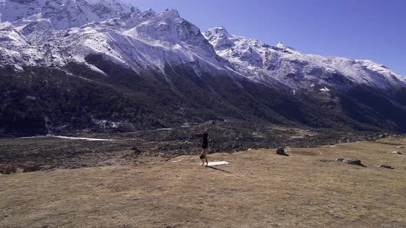 Man doing yoga in the Kyaniji Valley in Nepal alt