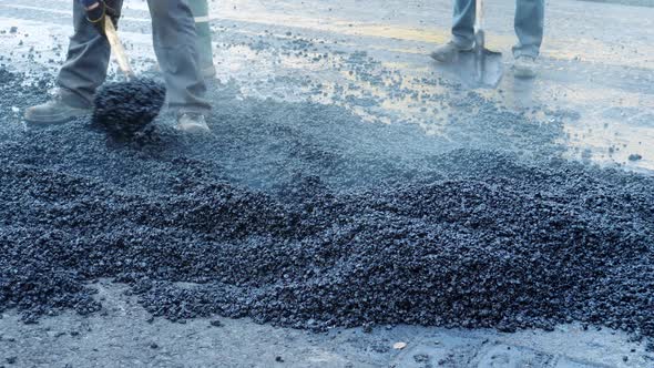 Workers Throw Hot Asphalt on Road