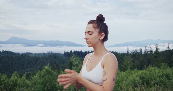 Young Woman with Closed Eyes Meditating on Nature alt