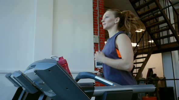 Attractive Young Sports Woman is Working Out in Gym, Girl Running on Treadmill and Drinks a Water