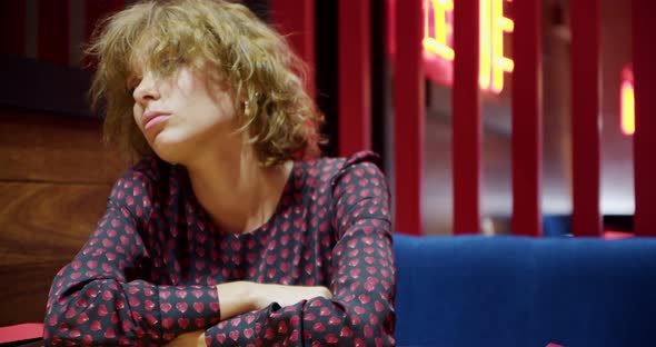 Portrait of a Saddened Bigeyed Young Woman with an Active Facial Expression Sitting Alone Waiting alt