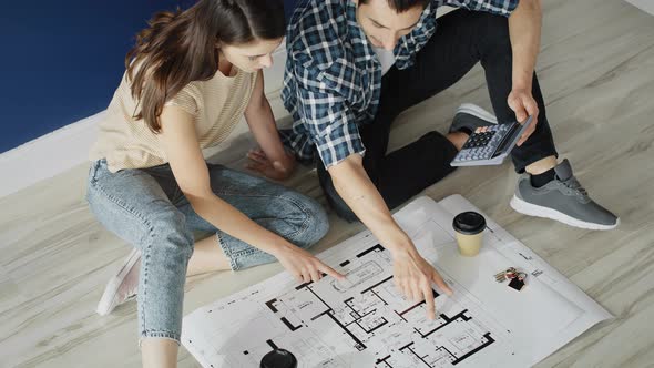 Top view video of couple counting the area of the new home. Shot with RED helium camera in 8K alt
