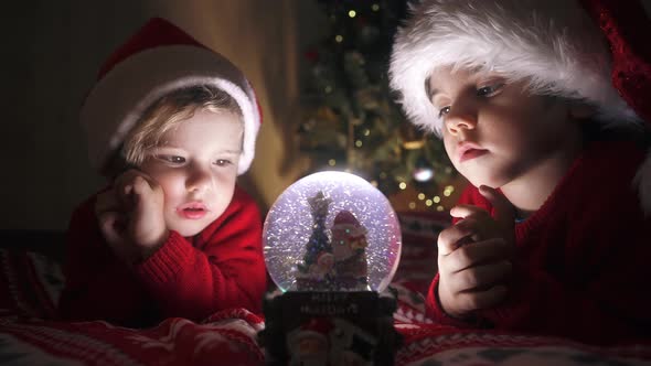 Cute Little Boys in Santa Hats with Snow Globe alt