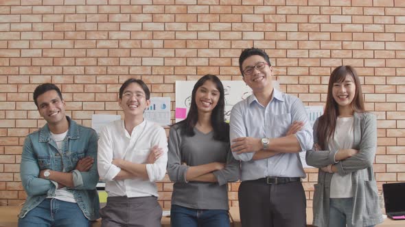 successful business looking at camera and smile, arms crossed in creative office. alt