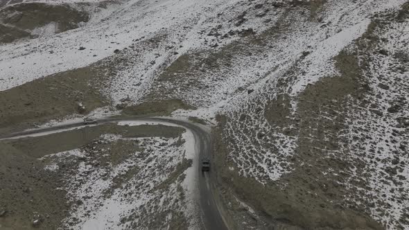 Aerial drone shot of car Aerial View Of Karakoram Highway Road Beside River At Hunza Valley. alt