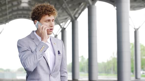 Young Handsome Business Man Waiting for Cab Making Phone Call Standing in Classic Suit and Calling
