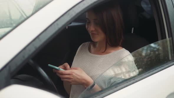 Happy Woman Sitting Inside Car Using a Smart Phone Voice Recognition Function Online Outdoors Speech alt
