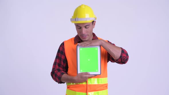 Young Happy Hispanic Man Construction Worker Talking While Showing Digital Tablet