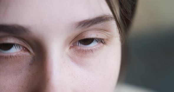 Young Woman Opens Her Eyes and Looking at the Camera