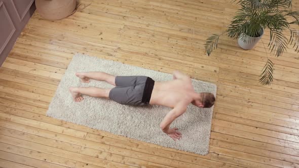 A Young European Man Works Out on a Wooden Floor alt
