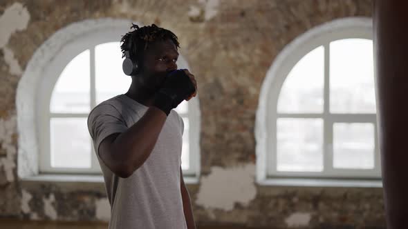African American Male Boxer Taking a Break to Drink From a Plastic Cup in Slow Motion alt