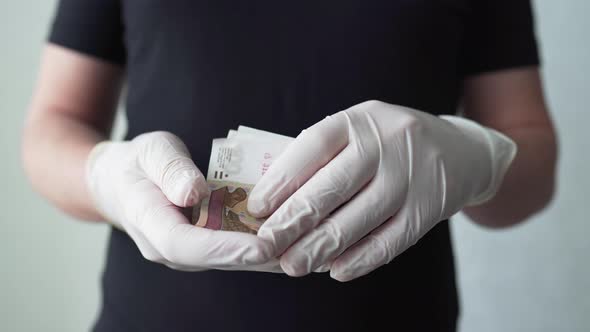 The Man Considers Russian Rubles in Protective Medical Gloves. Russian Money During the Covid-19