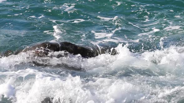 Sea Waves Rolling Over a Rock alt