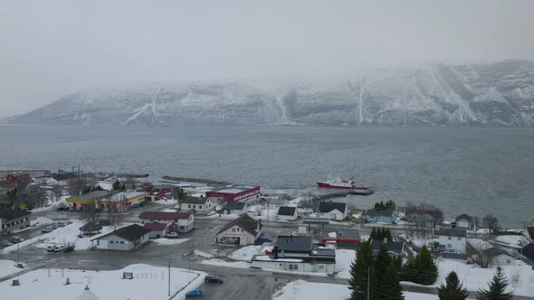 Kåfjord town centre and harbour in Olderdalen, Norway. Overcast winter weather.4k aerial drone shot alt