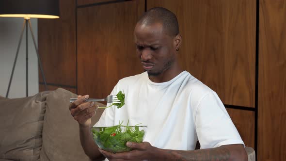 Young Black Man Forcing Himself to Eat Salad Dissatisfaction Diet for Weight Control alt
