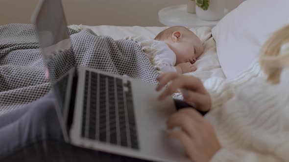 Closeup Laptop Keyboard Near Sleeping Baby in Bedroom