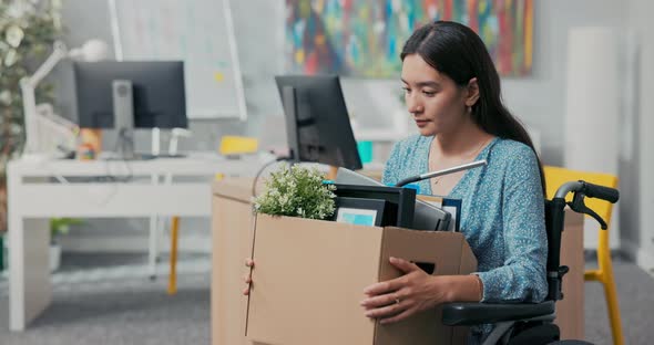 A Disabled Attractive Woman in Dress of Asian Korean Beauty Sits in Wheelchair at Corporate Desk on alt