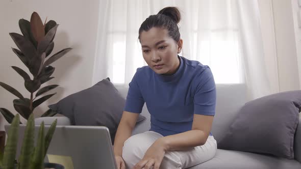 New normal Asian women are using cards to pay for online shopping on a laptop alt