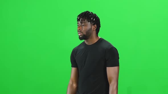 Portrait of African American Man with Dreadlocks Is Walking at Green Screen, Chroma Key alt